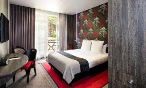a hotel room with a bed and a desk at Best Western Premier Le Patio des Artistes Wellness Jacuzzi in Cannes