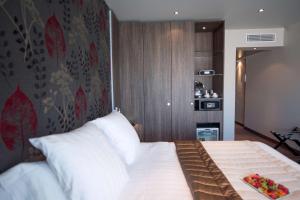 a bedroom with a large bed with white pillows at Best Western Premier Le Patio des Artistes Wellness Jacuzzi in Cannes