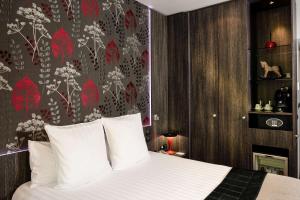 a bedroom with a bed with a red and white wallpaper at Best Western Premier Le Patio des Artistes Wellness Jacuzzi in Cannes
