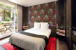 a hotel room with a bed and a balcony at Best Western Premier Le Patio des Artistes Wellness Jacuzzi in Cannes