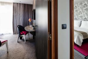 a hotel room with a bed and a desk and a table at Best Western Premier Le Patio des Artistes Wellness Jacuzzi in Cannes