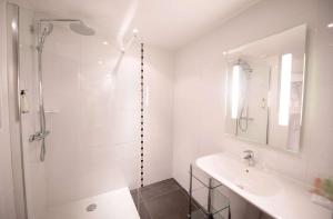 a white bathroom with a shower and a sink at Best Western Premier Le Patio des Artistes Wellness Jacuzzi in Cannes