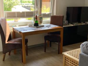 a desk with two chairs and a bottle of wine on it at Ankerplatz in Winnemark