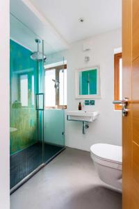 a bathroom with a shower and a toilet and a sink at Veeve - Rubix Cube Mews in London