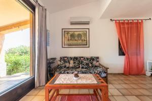 un soggiorno con divano e tavolo di Villetta Residence Porto Corallo a Villaputzu