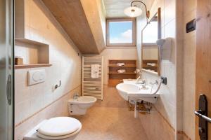 Un baño con dos lavabos y un inodoro y una ventana. en Appartamento Castagno Chalet Cambra, en Livigno 22 fotos más
