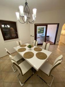 a dining room with a white table and chairs at Apartments Kosljun 123 in Košljun