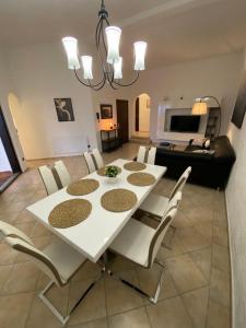 a dining room with a white table and chairs at Apartments Kosljun 123 in Košljun +83 photos