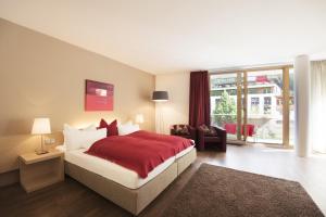 a bedroom with a large bed with a red blanket at Skihotel Galzig in Sankt Anton am Arlberg