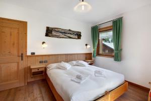 sypialnia z dużym białym łóżkiem i oknem w obiekcie Appartamento Larice Chalet Cambra w Livigno