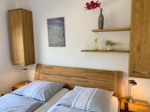 uma cama com uma cabeceira em madeira num quarto em Ferienwohnung "Fuchsbau" em Sankt Peter-Ording
