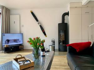 un soggiorno con divano nero e TV di Ferienwohnung "Fuchsbau" a Sankt Peter-Ording
