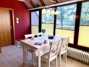 a dining room with a table and chairs and windows at Ferienwohnung "Laura" in Sankt Peter-Ording