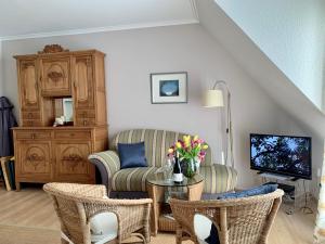 a living room with a couch and a chair and a television at Ferienwohnung "Leena" in Sankt Peter-Ording
