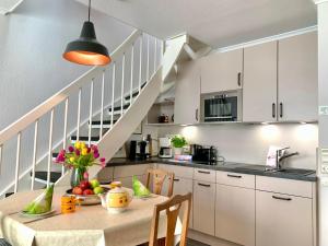 a kitchen with white cabinets and a table with fruit on it at Ferienwohnung "Leena" in Sankt Peter-Ording