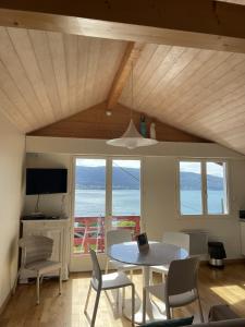 - une salle à manger avec une table et des chaises offrant une vue sur l'océan dans l'établissement Le cottage de Veyrier, très jolie vue Lac - LLA Selections by Location Lac Annecy, à Veyrier-du-Lac