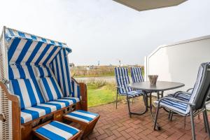 圣彼得奥尔丁Ferienwohnung "Böhler Strandperle"的庭院里摆放着一组椅子和一张桌子