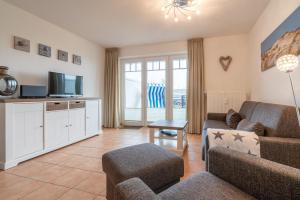 圣彼得奥尔丁Ferienwohnung "Böhler Strandperle"的客厅里有一张沙发和一台电视