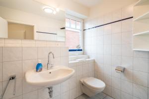 圣彼得奥尔丁Ferienwohnung "Böhler Strandperle"的带水槽和马桶的白色浴室