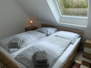 sypialnia z łóżkiem z białą pościelą i oknem w obiekcie Ferienwohnung "Westerheversand" w mieście Sankt Peter-Ording