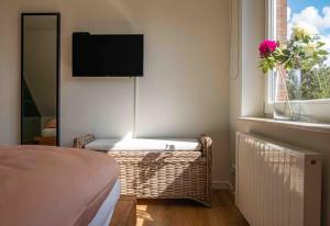 ein Schlafzimmer mit einem Bett und einem TV an der Wand in der Unterkunft Ferienhaus RH "Achter de Dün" in Sankt Peter-Ording