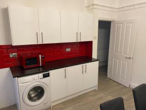 a kitchen with a washing machine and a microwave at St Pauls Rd - Townhouse Accommodation in Bradford +13 photos