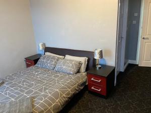 a bedroom with a bed with two night stands and two lamps at St Pauls Rd - Townhouse Accommodation in Bradford