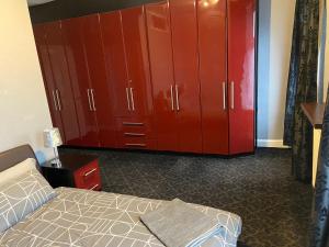 Schlafzimmer mit roten Schränken und einem Bett in der Unterkunft St Pauls Rd - Townhouse Accommodation in Bradford