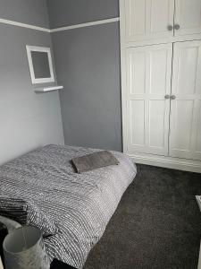 ブラッドフォードにあるSt Pauls Rd - Townhouse Accommodationのベッドルーム1室(ベッド1台、白いキャビネット付)