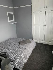 a bedroom with a bed and a white cabinet at St Pauls Rd - Townhouse Accommodation in Bradford