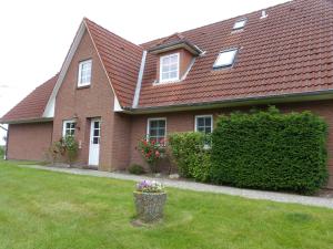 a brown brick house with a flower pot in the yard at Ferienwohnung "Frau Böhl" in Sankt Peter-Ording