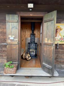 een open deur naar een kachel in een houten huis bij Obiralmhütte Meierhof in Bad Eisenkappel