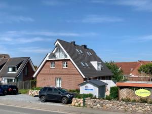 a black car parked in front of a house at Ferienhaus RH "Strandkieker Middenmang" in Sankt Peter-Ording
