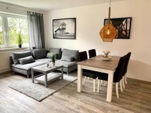 ein Wohnzimmer mit einem Tisch und einem Sofa in der Unterkunft Ferienwohnung "Fritz 17" in Sankt Peter-Ording