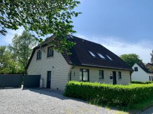 mały biały dom z czarnym dachem w obiekcie Ferienwohnung 3 in der Waldstraße w mieście Sankt Peter-Ording