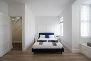 a white bedroom with a bed with a blue headboard at Spacious Holiday Home in Porthcawl in Porthcawl