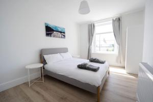 Habitación blanca con cama y ventana en Spacious Holiday Home in Porthcawl, en Porthcawl