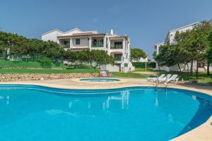 einen Pool mit Stühlen vor einem Haus in der Unterkunft Biniforcat 11 in Cala en Forcat