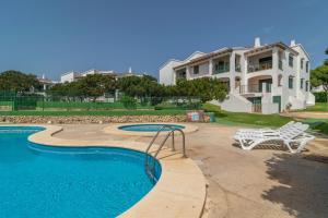 einen Pool mit einer Bank und einem Haus in der Unterkunft Biniforcat 11 in Cala en Forcat