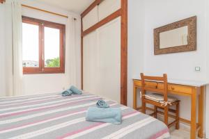 ein Schlafzimmer mit einem Bett, einem Schreibtisch und einem Stuhl in der Unterkunft Biniforcat 11 in Cala en Forcat + 21 Fotos