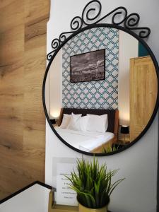 um espelho numa parede com uma cama num quarto em B&B Dolac em Zagreb