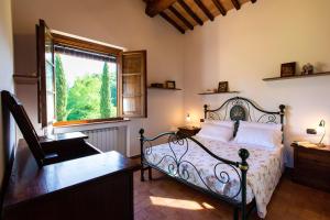 1 dormitorio con cama y ventana en Via Francigena Cottage in the Green, en San Gimignano