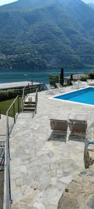 um pátio com cadeiras e uma piscina ao lado da água em Villa Ortensia em Laglio