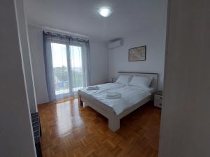 - une chambre avec un lit et une grande fenêtre dans l'établissement Violeta, à Crikvenica
