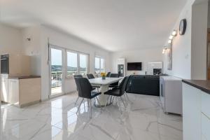 cocina y sala de estar con mesa y sillas en Apartment M&A en Trogir