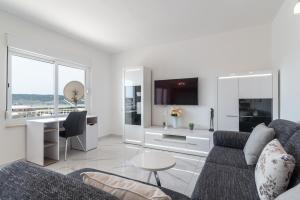 een witte woonkamer met een bank en een bureau bij Apartment M&A in Trogir