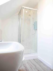 uma casa de banho branca com um chuveiro e um lavatório. em Beautiful 3bedroom townhouse in a new estate em Great Yarmouth