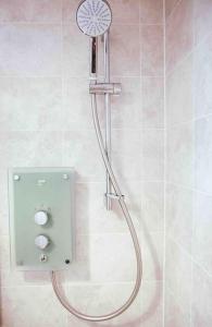 uma casa de banho com uma cabeça de chuveiro em Beautiful 3bedroom townhouse in a new estate em Great Yarmouth