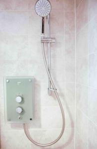 a shower with a shower head in a bathroom at Beautiful 3bedroom townhouse in a new estate in Great Yarmouth +21 photos