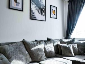 een woonkamer met een grijze bank met kussens bij Beautiful 3bedroom townhouse in a new estate in Great Yarmouth